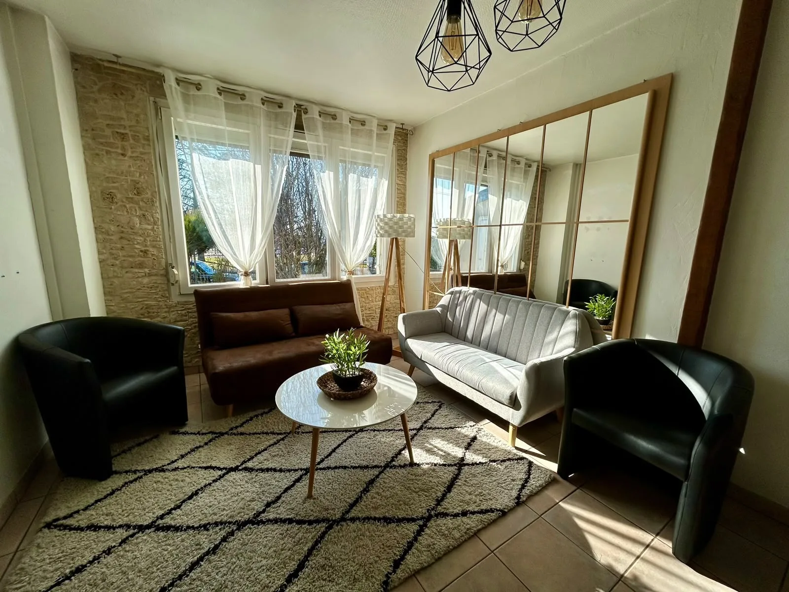 Salon lumineux avec canapés et tapis berbère