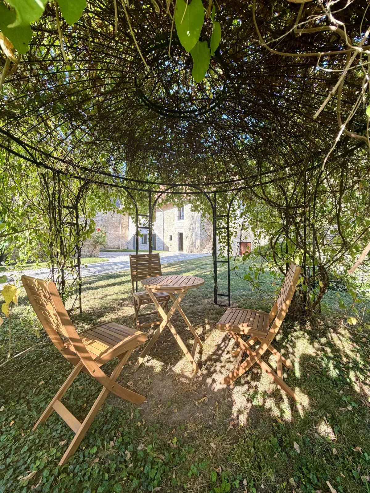 Salon de jardin sous une tonnelle ombragée